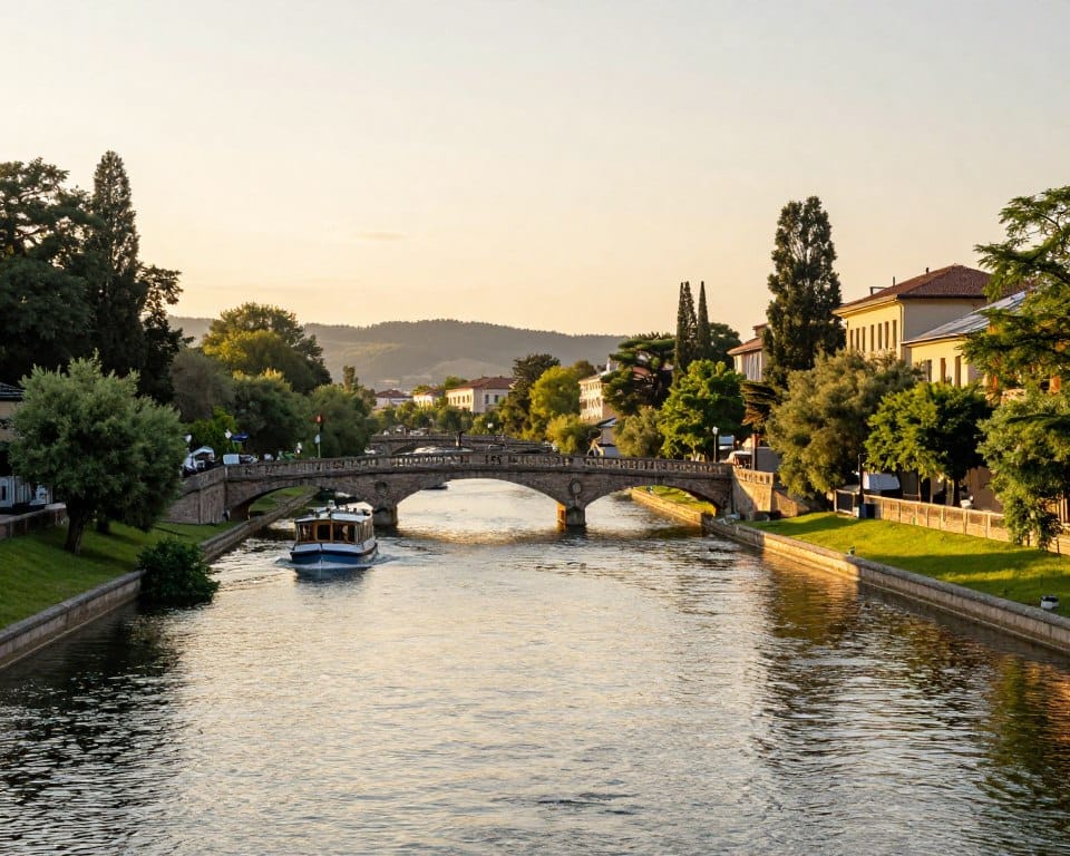 A serene and picturesque canal system during sunset, showcasing elegant engineering marvels. In the foreground, gently flowing waters reflect the warm hues of the sky, with lush greenery bordering the banks. In the middle ground, classic arched stone bridges span over the canals, with boats peacefully gliding beneath, demonstrating the harmony between nature and human ingenuity. On the backdrop, distant rolling hills and historical buildings hint at the region's rich architectural legacy. The scene is illuminated with soft, golden lighting, casting long shadows and enhancing textures throughout. The image captures a tranquil yet vibrant atmosphere, emphasizing the significance of canals in enabling long-distance navigation. Focused, high detail, and natural colors bring the engineering breakthroughs to life, inviting viewers to appreciate their historical impact.